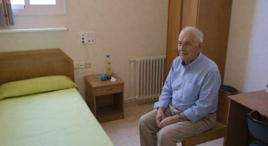 Persona mayor con Alzheimer en habitación individual luminosa y acogedora